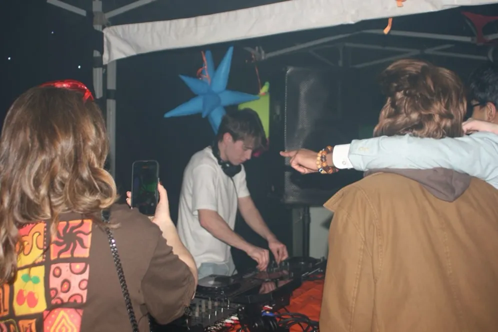 MC Cal DJing outdoors under a canopy at night