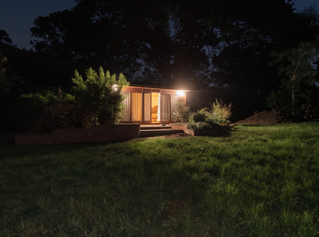 Harry’s garden cabin at night with lights on